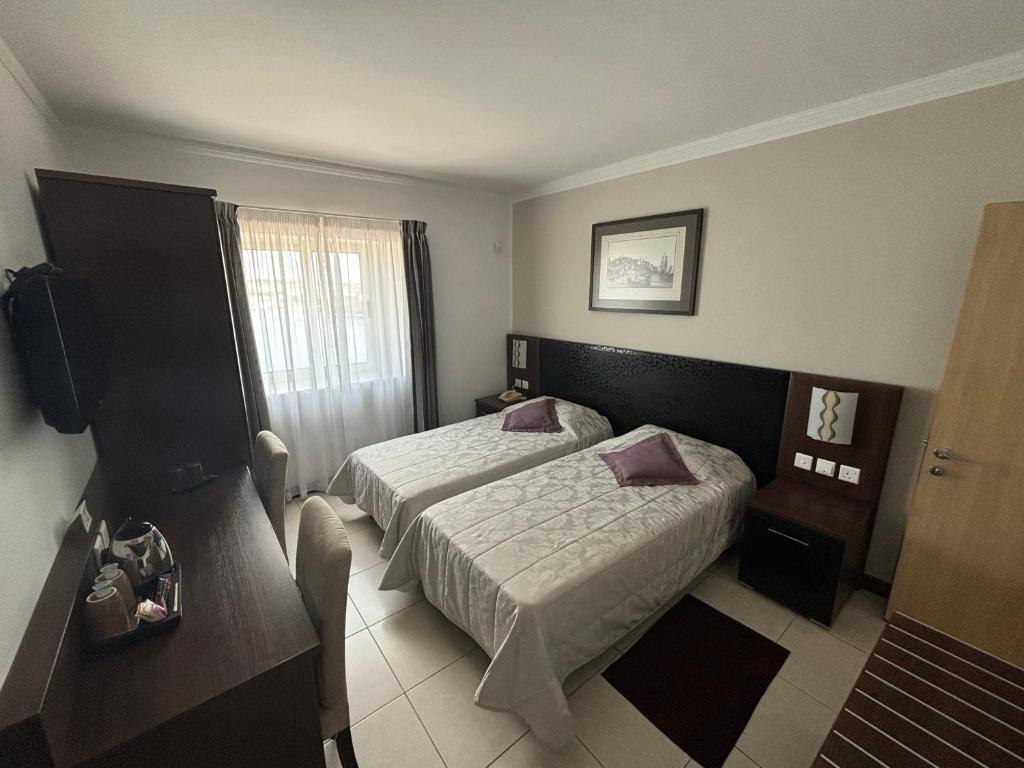Postel nebo postele na pokoji v ubytování Grand Harbour Hotel
