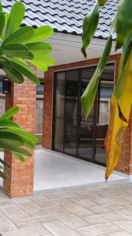 a glass door of a house with green leaves at Chiang Mai: Quiet BDR for Two in Green Area in Chiang Mai