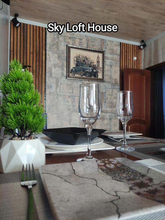 a table with two wine glasses and a sly lot house at Sky loft house in Almaty