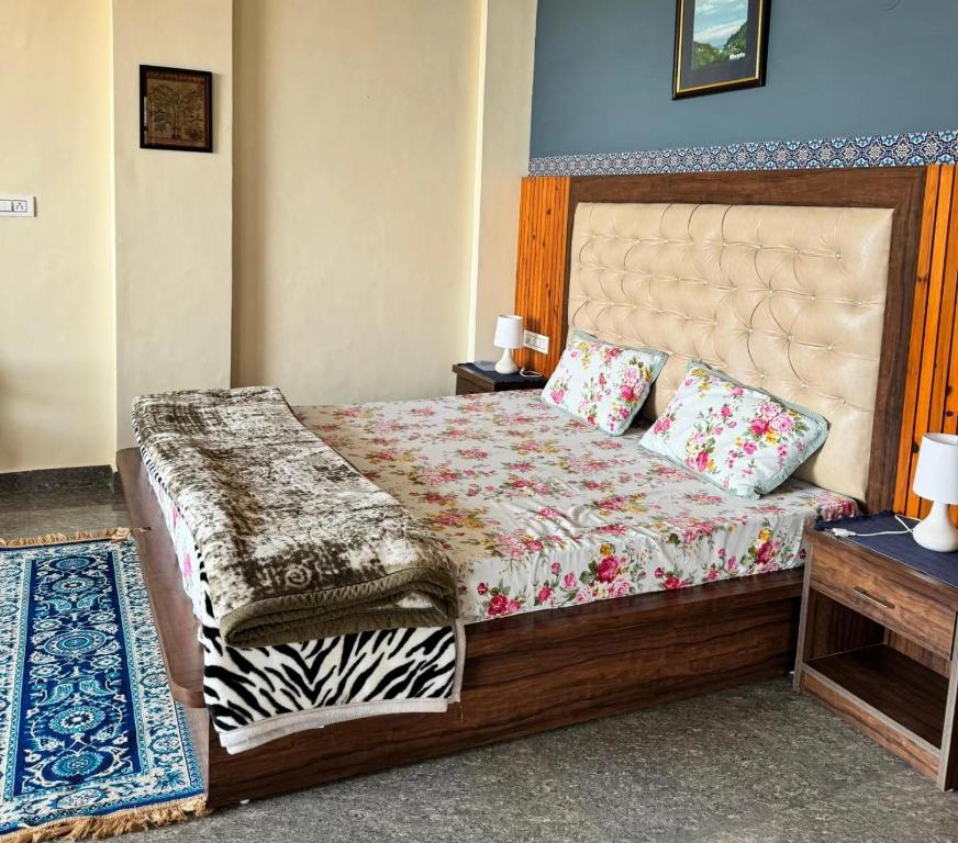 a bedroom with a large bed with a wooden headboard at Villa Vikas Studio in Dharamshala