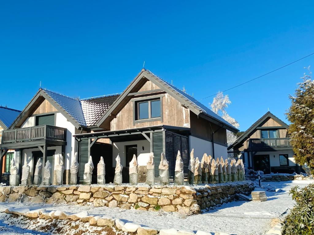 a house with a stone fence in front of it at Domek na szlaku in Szklarska Poręba