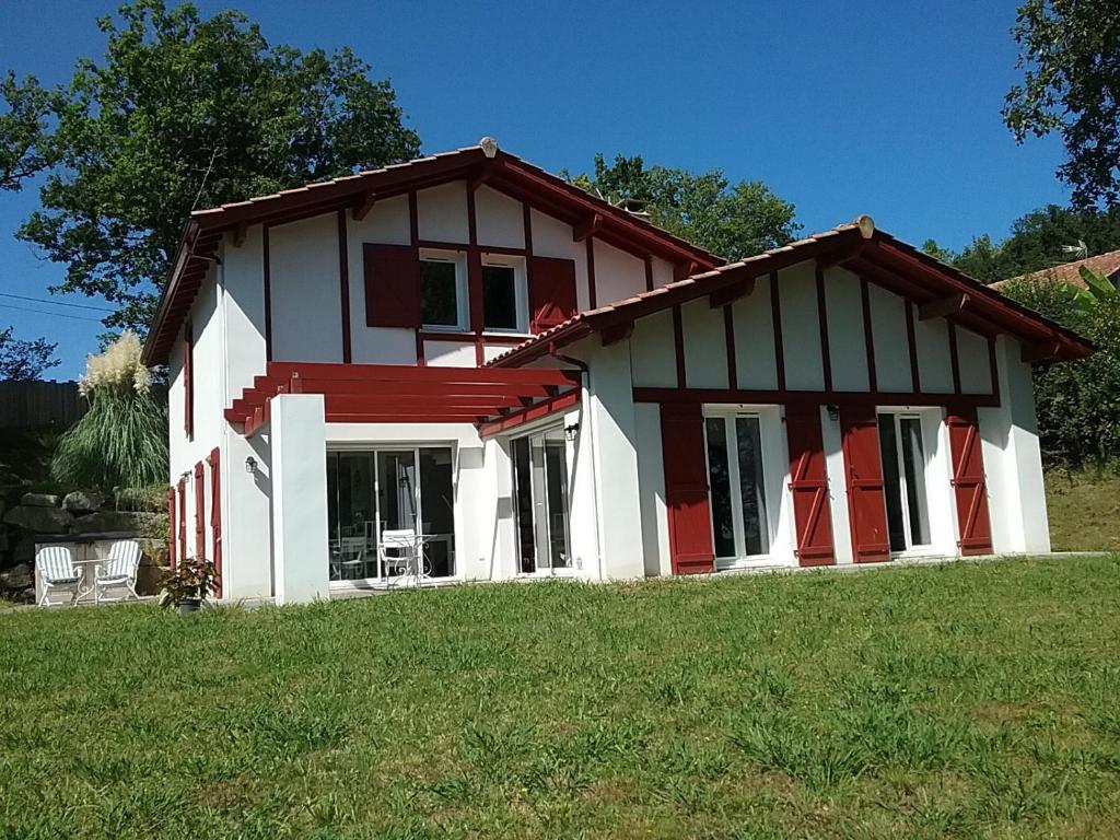 a small house with red and white trim on a field at T3 cadre champêtre Saint Jean de Luz in Saint-Pée-sur-Nivelle