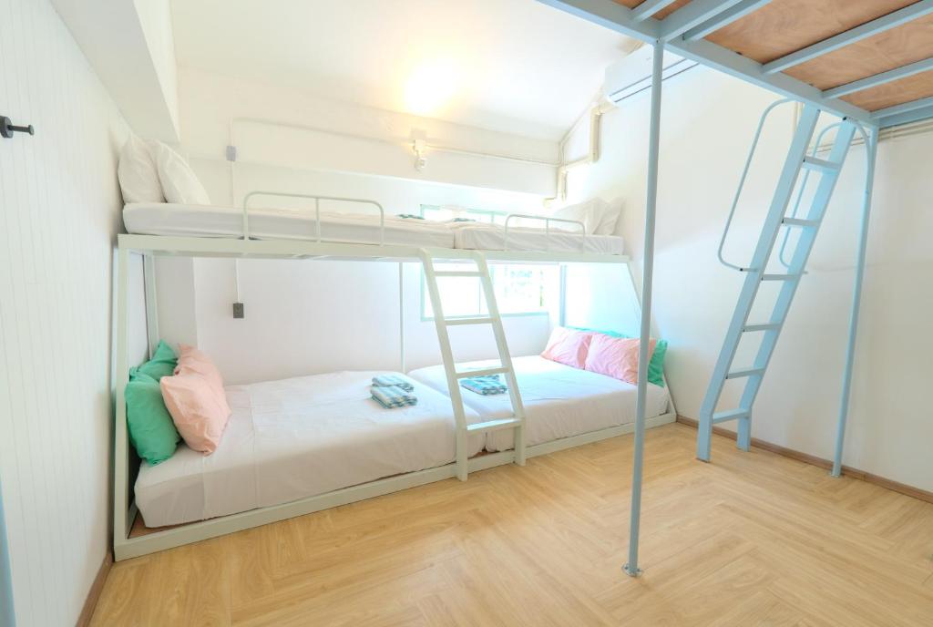 a bunk bed room with two bunk beds and a ladder at Green Group Stay Bangkok - Near Khaosan Road in Bangkok