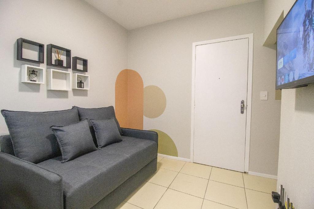 Una sala de estar con un sofá y un televisor. en JOA23 - 1 Dorm, Climatizado, Garagem, TV Smart, en Balneário Camboriú