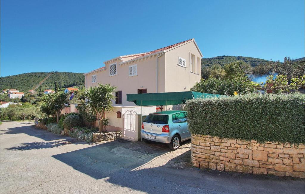 une voiture garée devant une maison dans l'établissement Three-Bedroom Apartment In Racisce, à Račišće