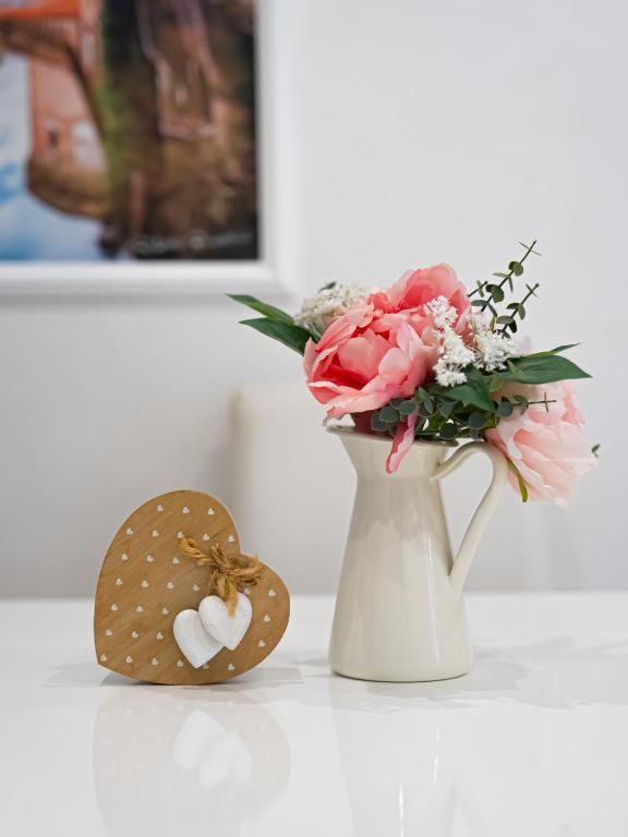 a vase with pink flowers and a cookie next to it at Casetta 46 in Ostia Antica