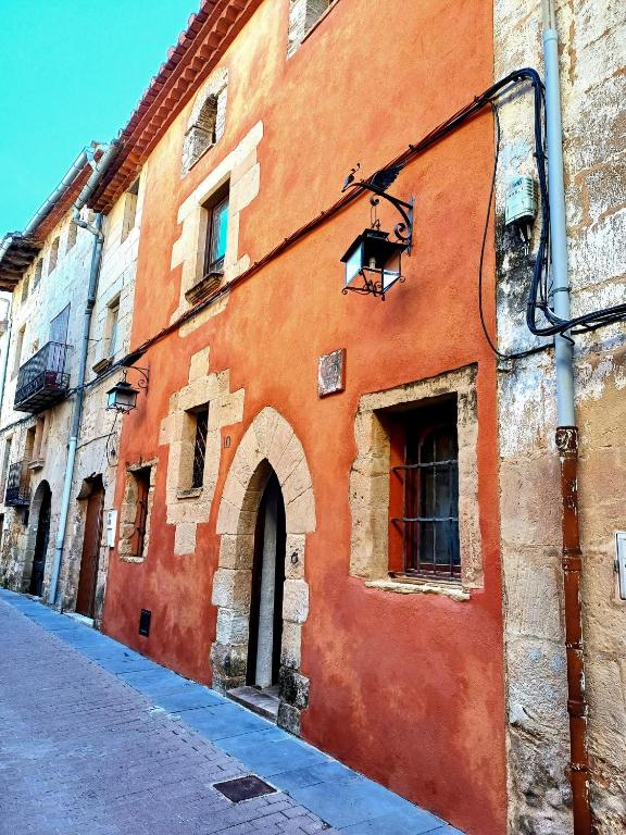 an orange building with a window on a street at La Querala in Cabanes