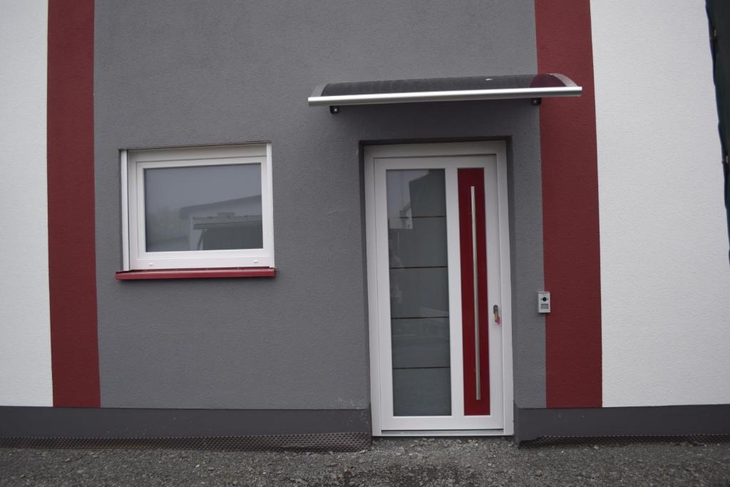 un edificio con una porta e due finestre di Ferienhaus 2 - 55471 Reich - EG - OG a Reich