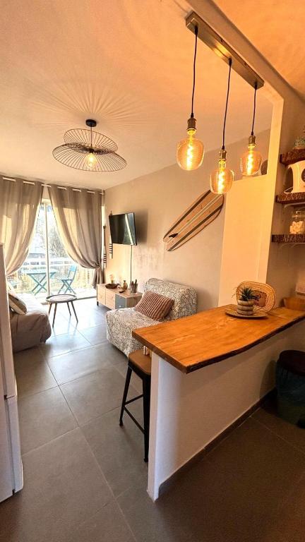 une cuisine avec une table et un salon dans l'établissement Plages 130 m, parking privé, climatisé, wifi/fibre, à Valras-Plage