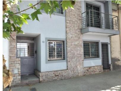 een huis met een deur en een bakstenen gebouw bij Departamentos Corazón in San Rafael