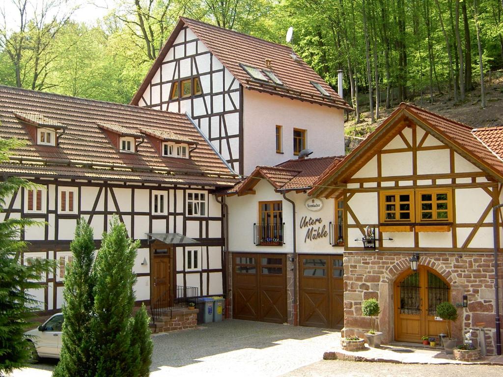 ein Haus mit einer Garage und einem Gebäude in der Unterkunft Pension Untere Mühle in Burghaun