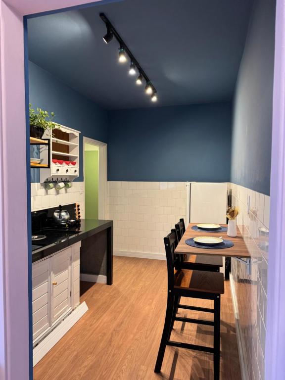 a kitchen with a table and chairs in a room at Apê Coloridinho - Centro in Serra Negra