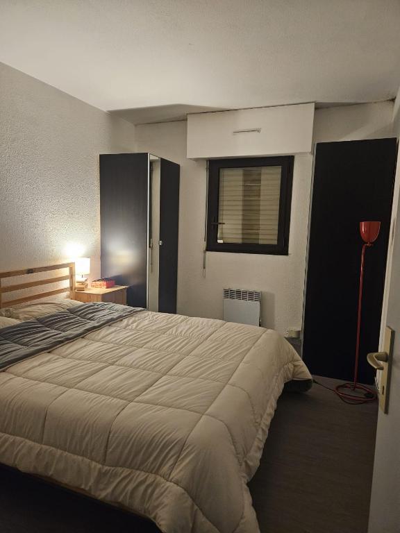 Un dormitorio con una cama grande y una ventana. en Chambre proche de la gare de Pessac, en Pessac