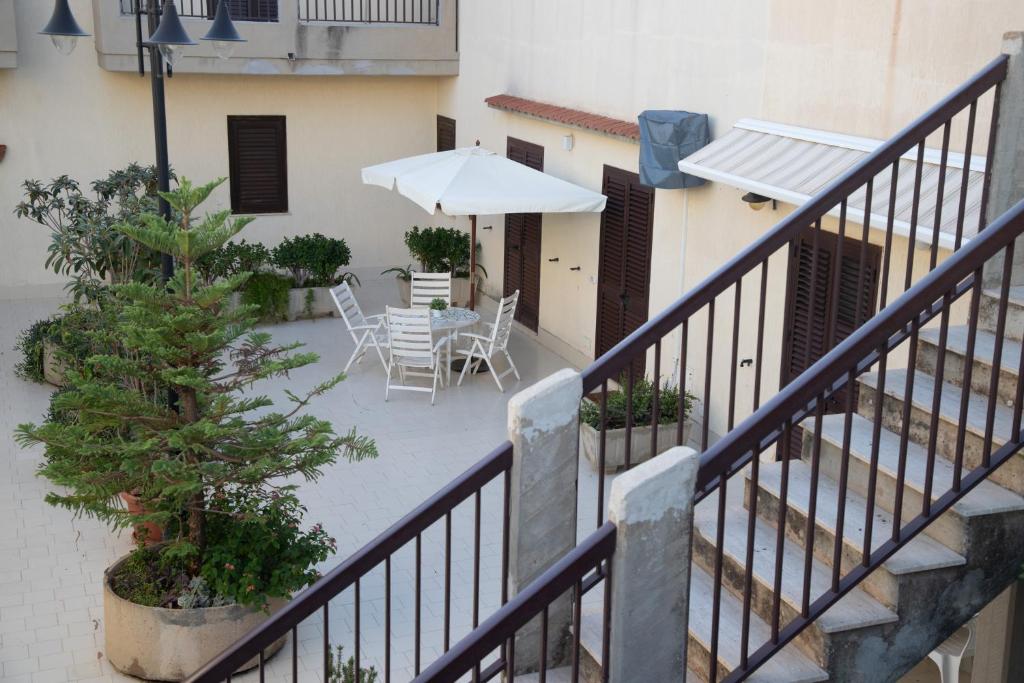 a balcony with a table and an umbrella at Casa Kaukana - A Pochi Passi dal Mare in Villaggio Azzurro