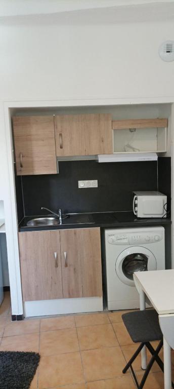 une cuisine avec un évier et une machine à laver dans l'établissement Location Studio manosque Centre ville, à Manosque
