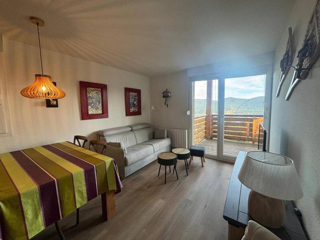 Cet appartement comprend une chambre avec un lit et un canapé ainsi qu'un salon. dans l'établissement Bel appartement T2 cabine avec vue sur lac, balcon et parking couvert - FR-1-593-4, aux Angles