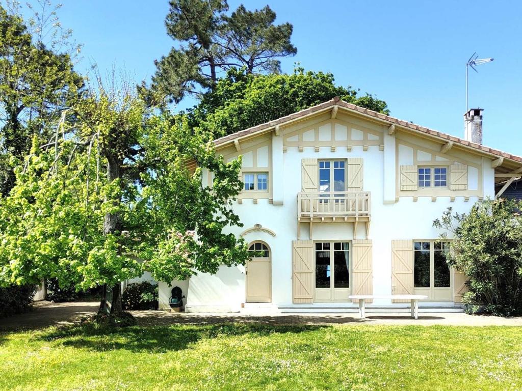 une maison blanche avec un banc devant dans l'établissement Belle maison à 50m de la plage et proche commerces - FR-1-736-28, à Lège-Cap-Ferret