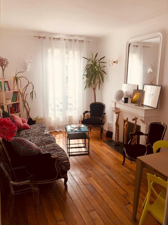 un salon avec un canapé et une table dans l'établissement appartement Cozy Paris Canal St Martin, à Paris