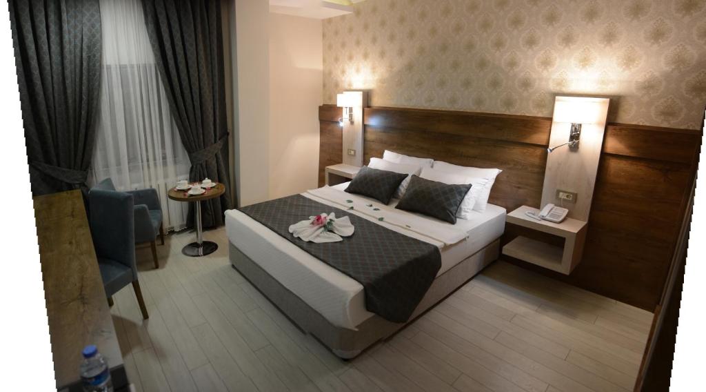 una camera d'albergo con un grande letto e una sedia di White Star Hotel ad Adıyaman