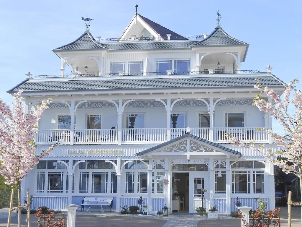 ein großes weißes Haus mit einer weißen Veranda in der Unterkunft Haus Midsommer in Timmendorfer Strand