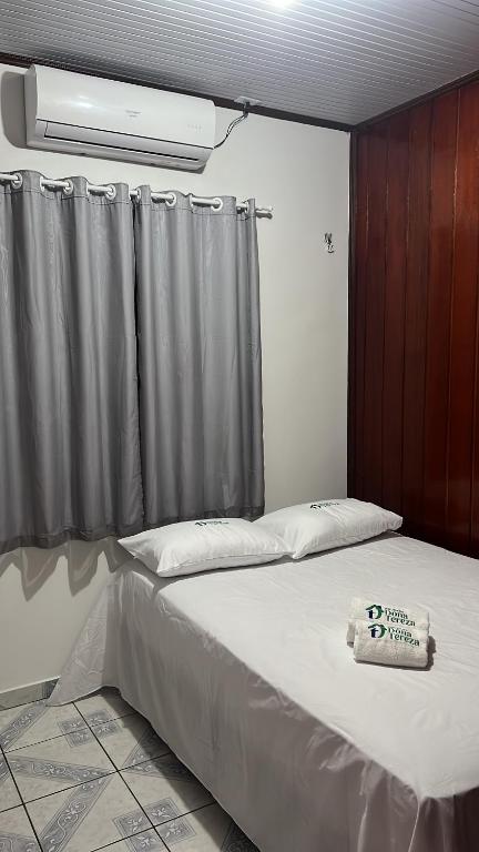 a bedroom with a bed with a curtain at Pousada Dona Tereza in Mâncio Lima