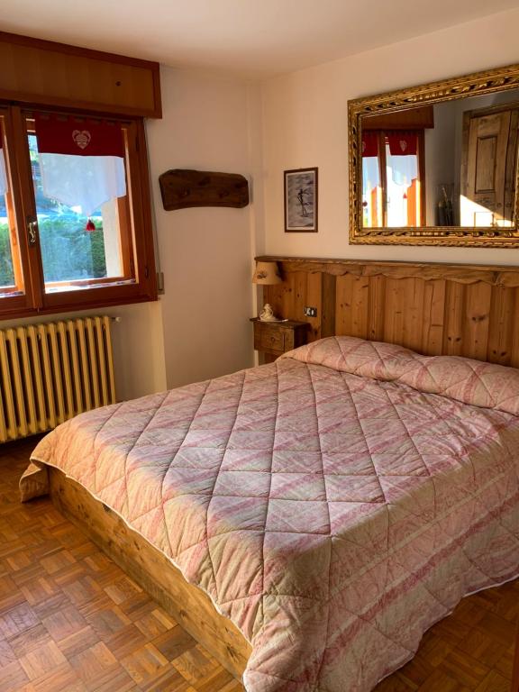 une chambre avec un lit et un miroir dans l'établissement Monica's apartment Viola, à Sauze dʼOulx