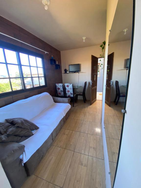 a room with a bed and a couch and a table at Apartamento em Torres RS in Torres