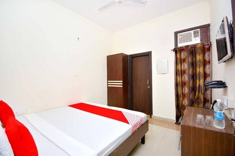 a bedroom with a bed and a table and a door at Hotel O Prince Paradise in Amritsar