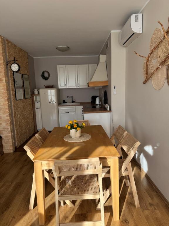 kuchnia i jadalnia z drewnianym stołem i krzesłami w obiekcie Apartament Zeta - Zeta Park w Ustroniu