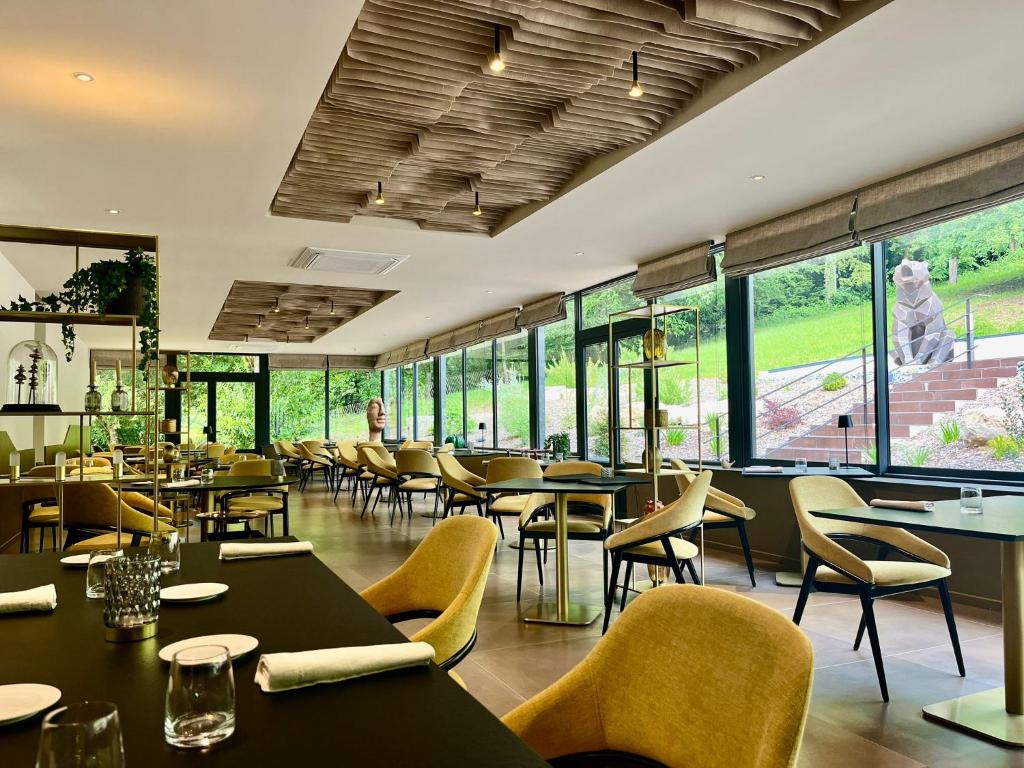 保拉扎克Richard Lequet Domaine gastronomique du Val d Atur的有桌椅和窗户的餐厅