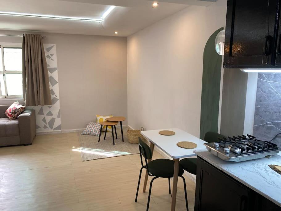 伊夫兰Cozy App in the Heart of Ifrane的配有桌椅的厨房和客厅
