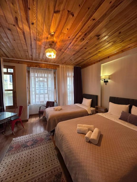 Un dormitorio con dos camas y techo de madera. en NarPera Taksim Boutique Hotel, en Estambul