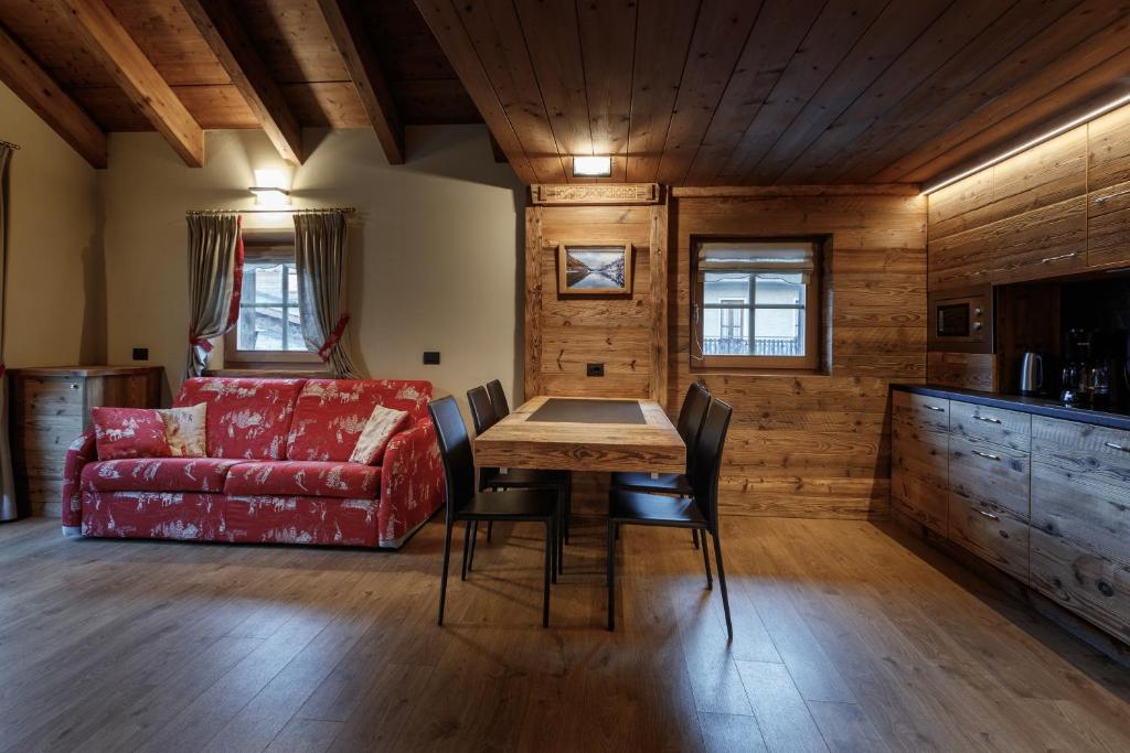 uma sala de estar com uma mesa e um sofá vermelho em Chalet Jolie em Livigno