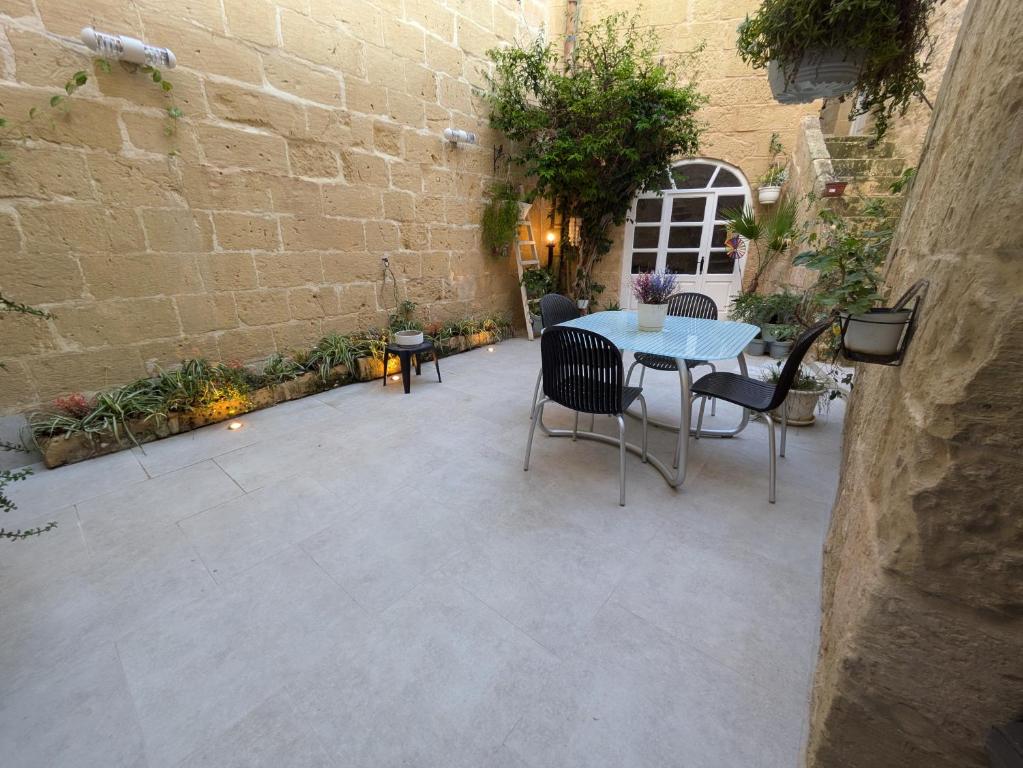 a patio with a table and chairs in a courtyard at Traditional Maltese House in centre of Town in Mosta