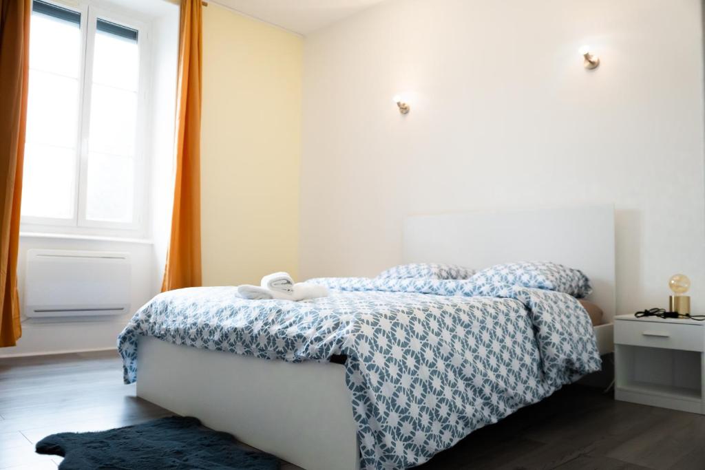 une chambre avec un lit avec une couette bleue et blanche dans l'établissement La Shekinah-Chambre dorée, au Creusot
