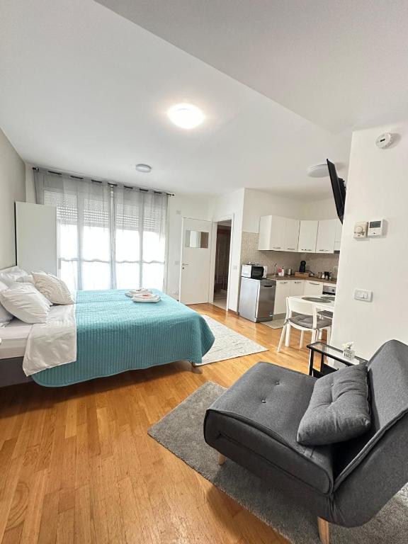 a bedroom with a bed and a couch and a kitchen at SanRaffaele 117 - Ospedale & Metro Milano - Intero Appartamento in Vimodrone