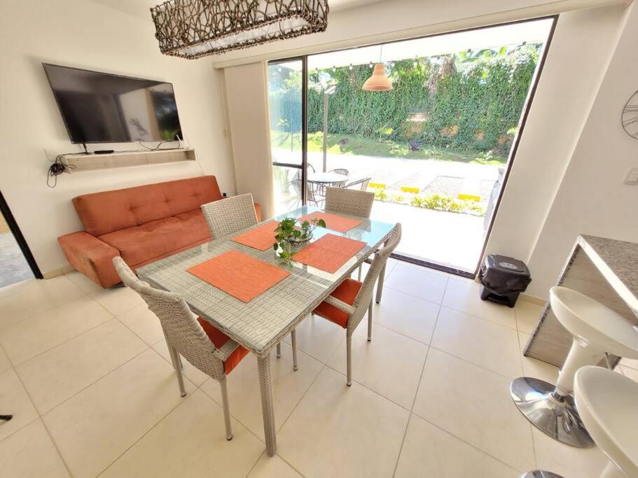 a dining room with a table and chairs and a couch at F111- Apartamento cerca al Club Campestre con piscina in La Tebaida