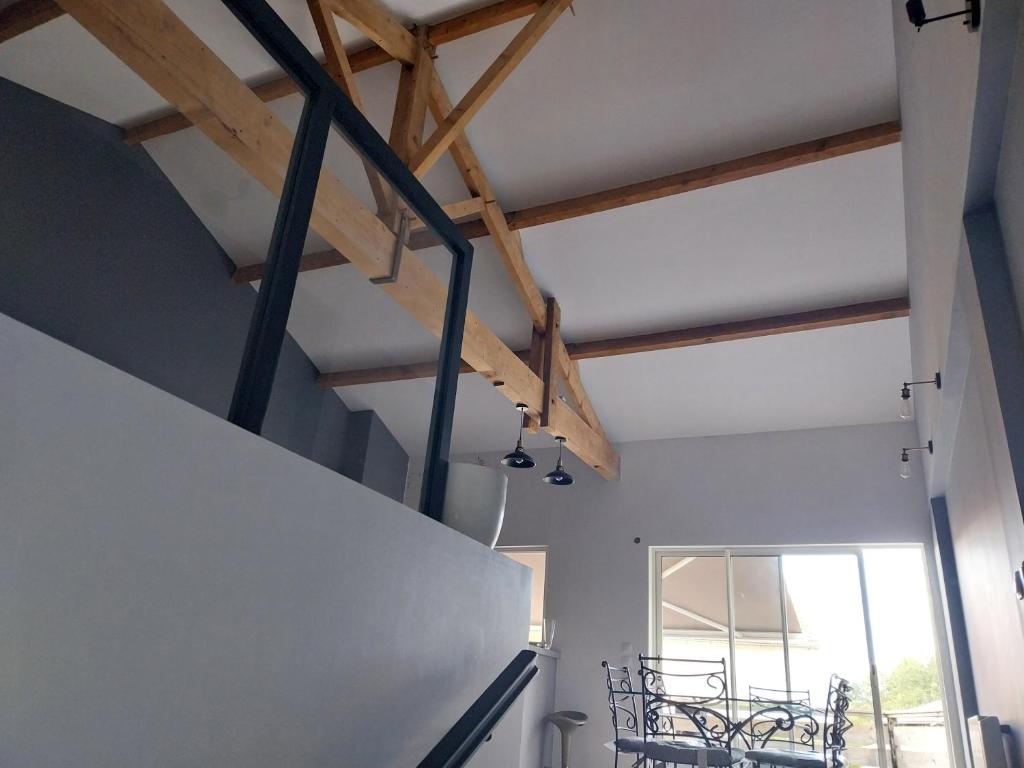 a room with wooden beams and a dining table at Julie in Saint-Bonnet-sur-Gironde
