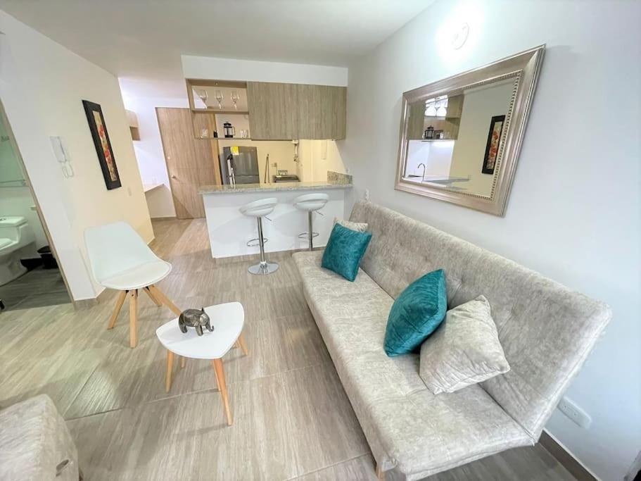 una sala de estar con un sofá y una mesa en M510- Apartaestudio en Av19 Norte con parqueadero, en Armenia