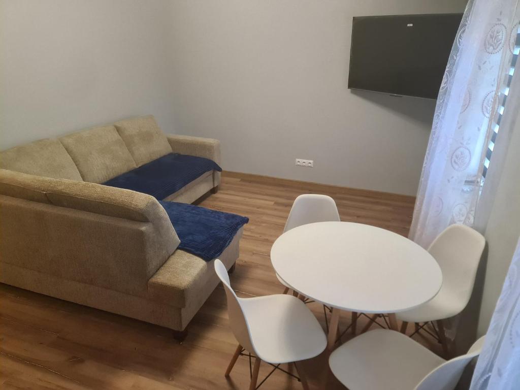 a living room with a couch and a table and chairs at Apartament mieszkanie do wynajęcia Justyna in Walim