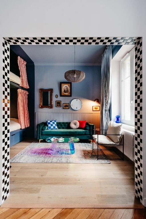 un salon avec un canapé vert et une table dans l'établissement Chez Lucie COZY RBNB, à Strasbourg