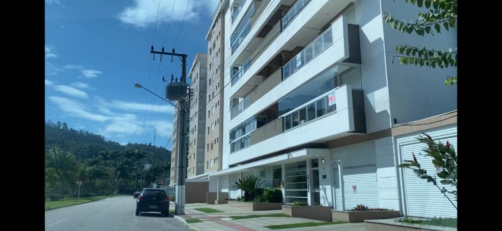 ein Auto ist vor einem Gebäude geparkt in der Unterkunft LINDO APARTAMENTO NOVO PARA 6 PESSOAS EM PALMAS. in Governador Celso Ramos