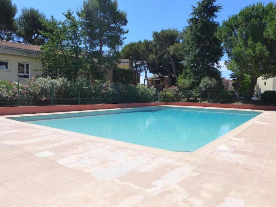une piscine dans une cour avec une maison dans l'établissement Appartement 2 pièces avc piscine, à Villeneuve-Loubet
