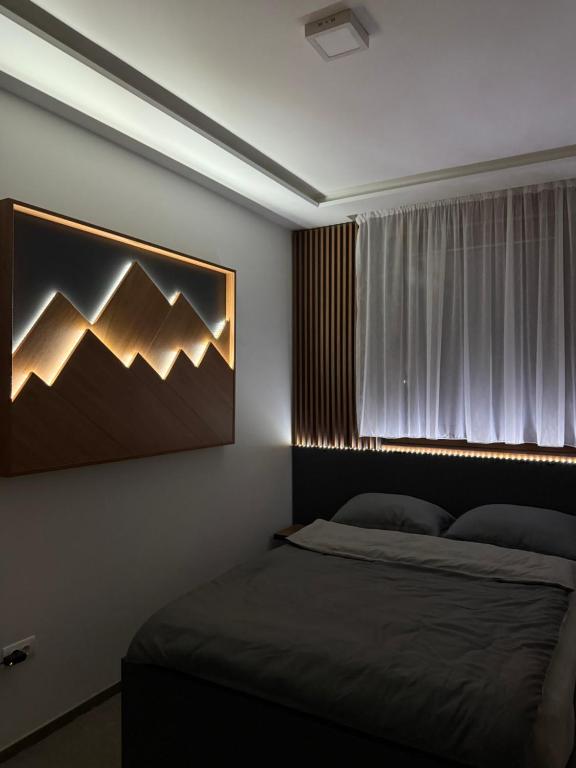 a bedroom with two beds and a large window at Duspara lux apartment Jahorina in Jahorina