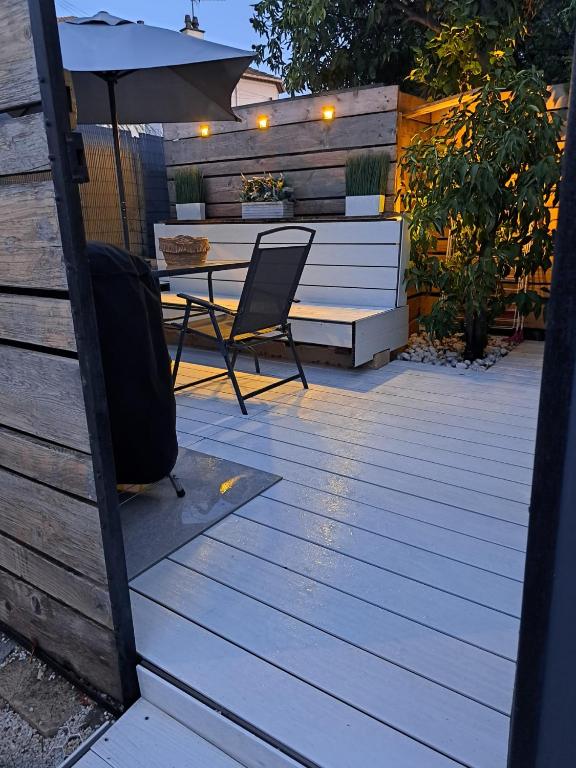 une terrasse en bois avec une table et un parasol dans l'établissement Séduisant studio avec cour privative, à La Crau