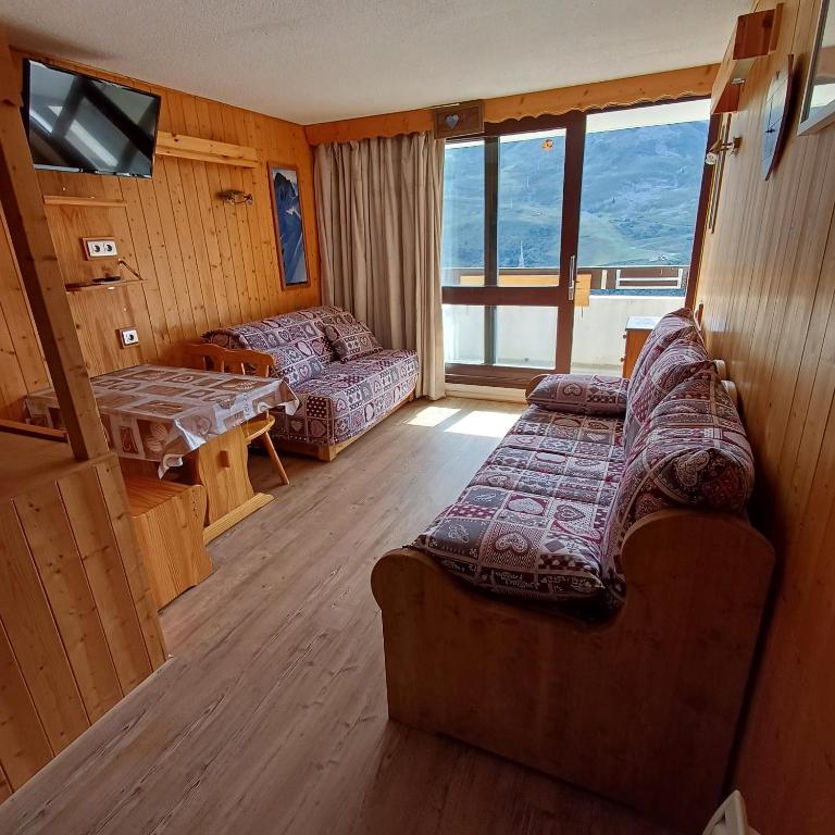 a room with a couch and a table in a room at Les Menuires Résidence Brelin Skis aux pieds in Les Menuires