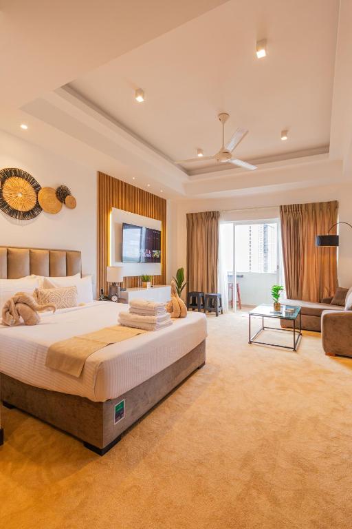 a large bedroom with a large bed and a couch at Negombo Beach - The Breeze by Roshi in Negombo