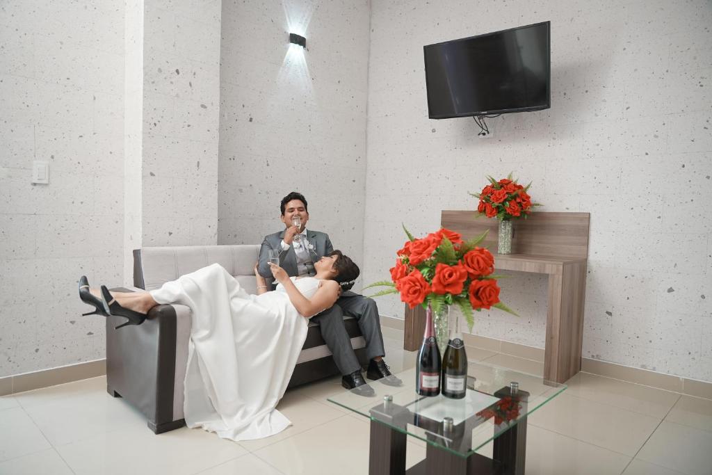 a man and a woman sitting on a couch at Hoteles Gutiérrez Mansión in Arequipa