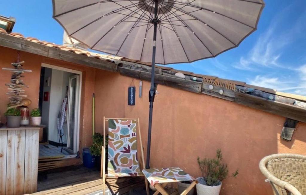 une terrasse avec un parasol dans l'établissement Appartement 2 chambres dans le centre de Cogolin, à Cogolin