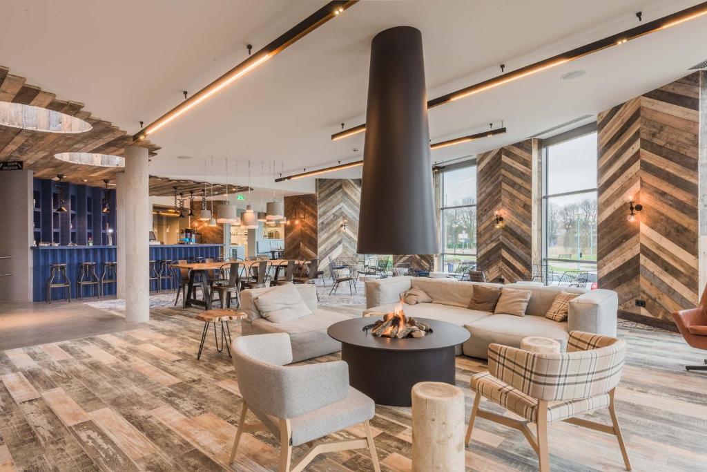 a living room with a couch and chairs and a fireplace at Urban Lodge Hotel in Amsterdam